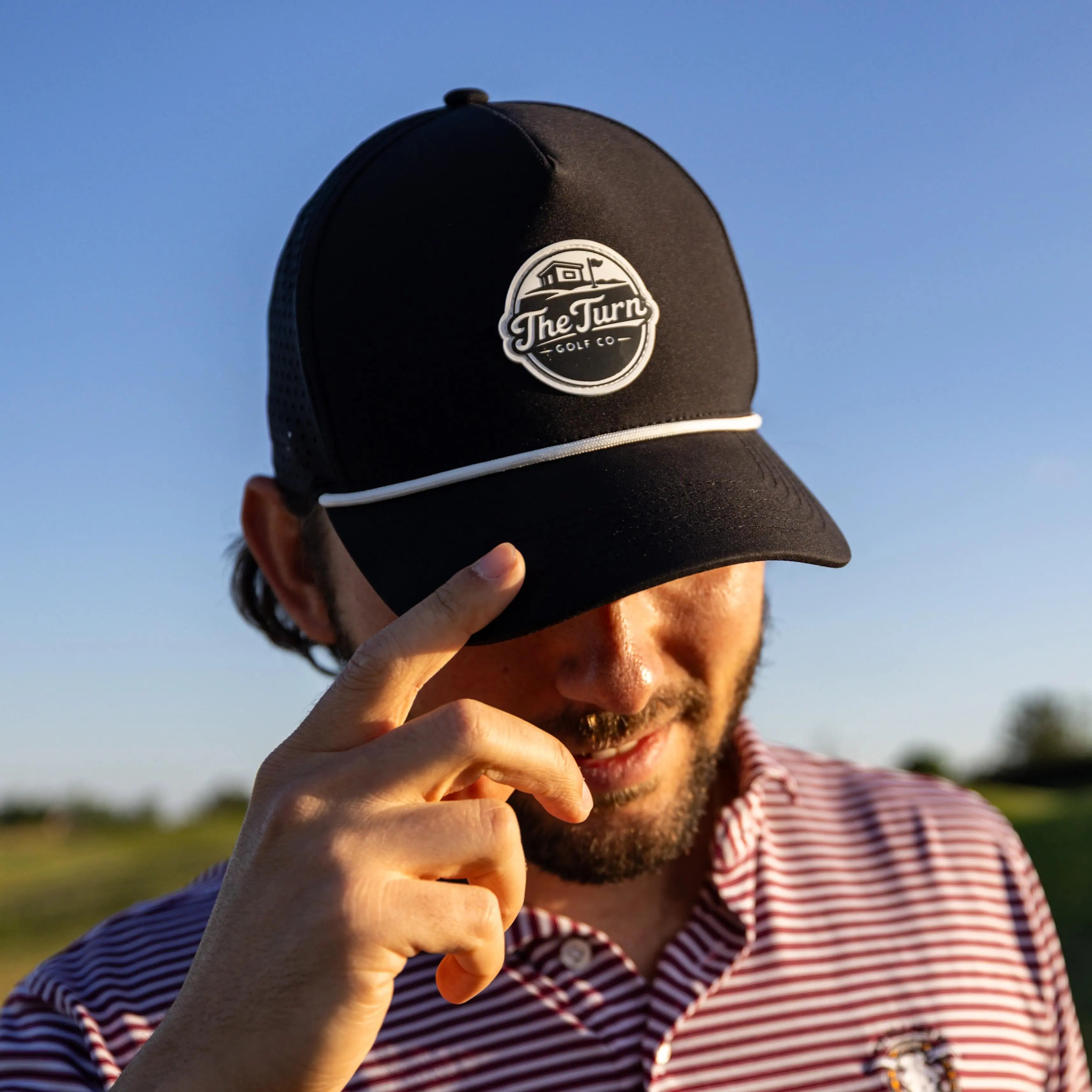 man in black golf hat